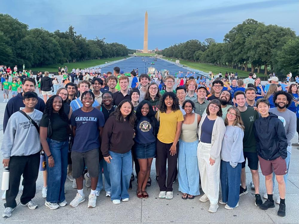 A group of Truman Scholars posing together on the National Mall with the Washington Monument behind them.